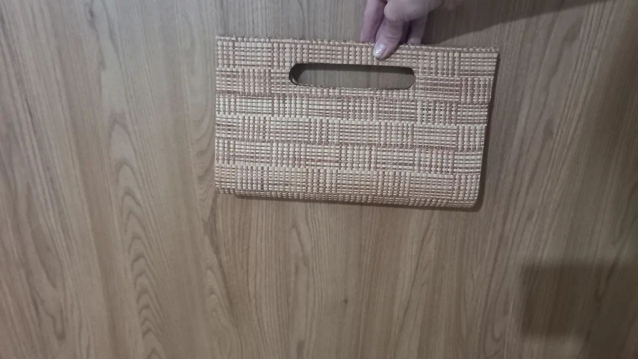 Vendo uma carteira de mão de palha.