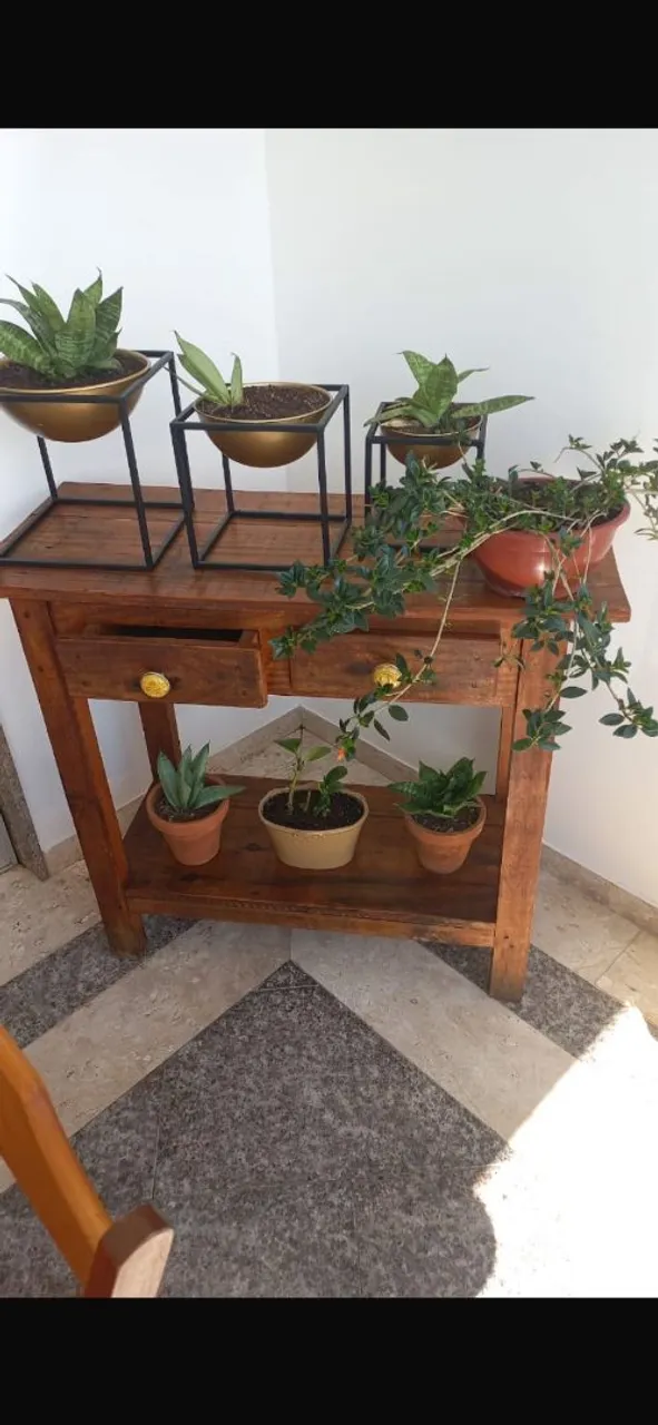 Mesa de madeira com gavetas e prateleira para plantas