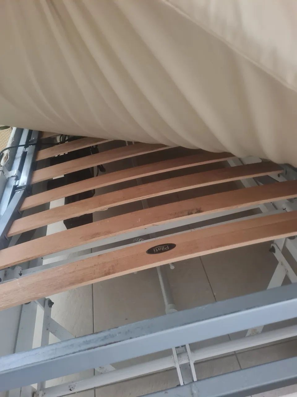 Cama hospitalar com colchão e  grades.