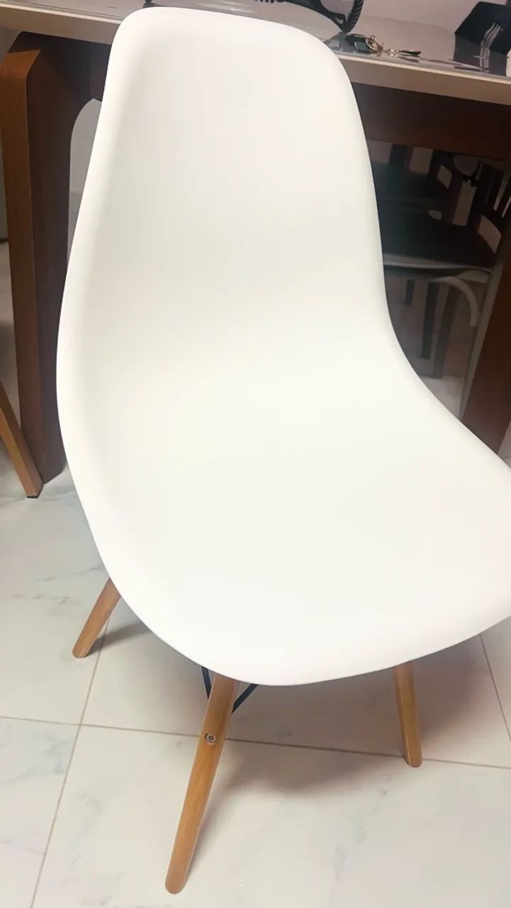 Cadeira branca estilo Eames com pés de madeira