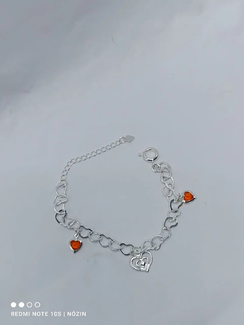Pulseira banhada com corações em zircônia laranja.