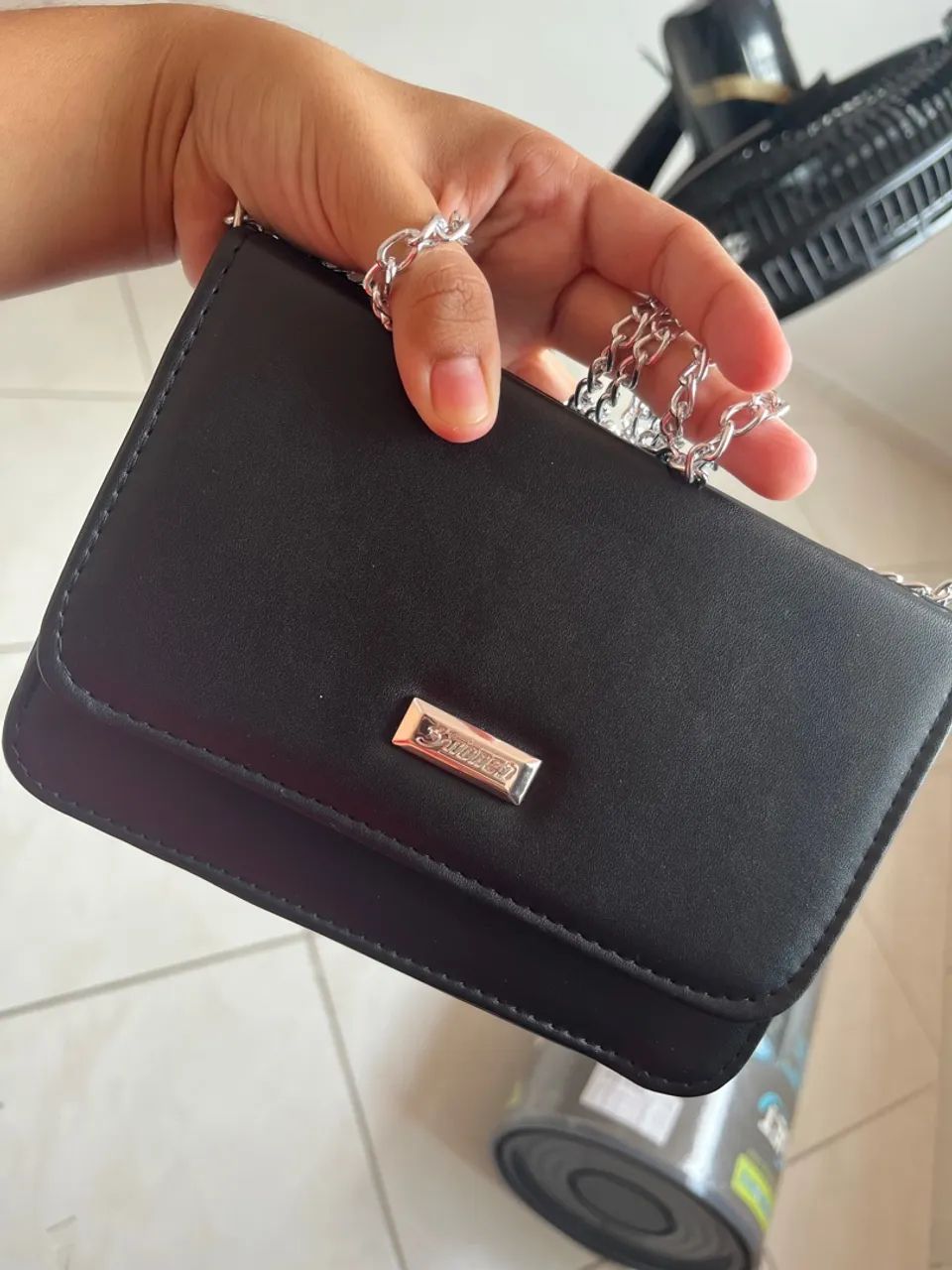 Bolsa preta com corrente.