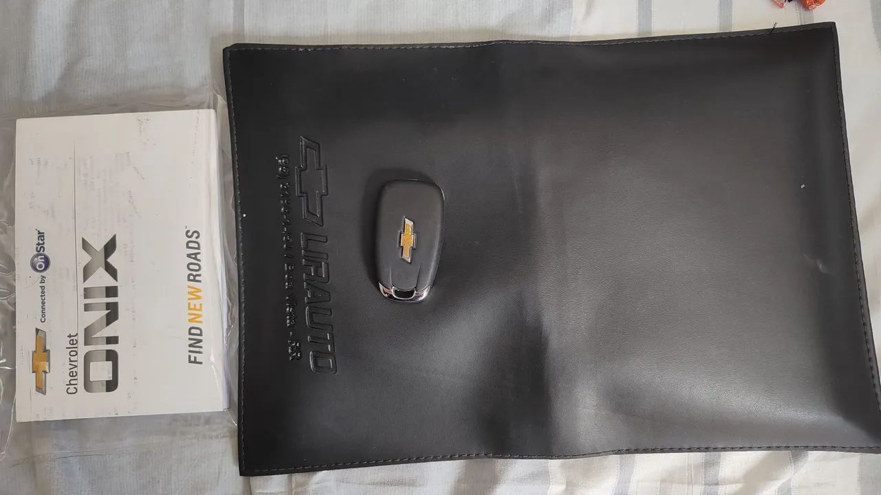 Chave do Onix 2020 e uma pasta de documentos com o manual 