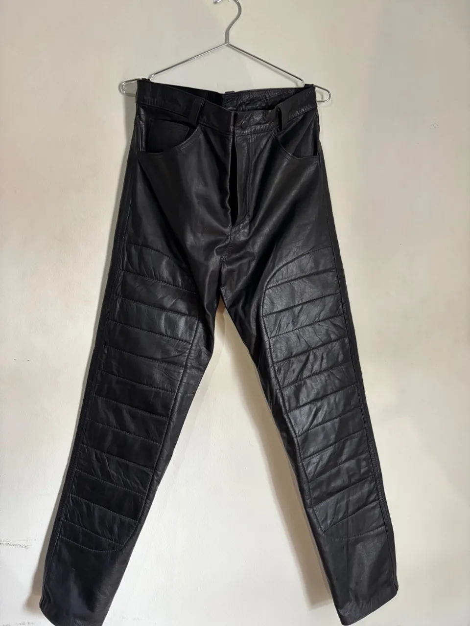 Calça de couro preta com detalhes acolchoados