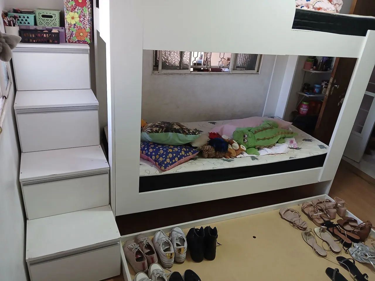 Cama beliche com uma cama adicional com quatro gavetas que sao escadas