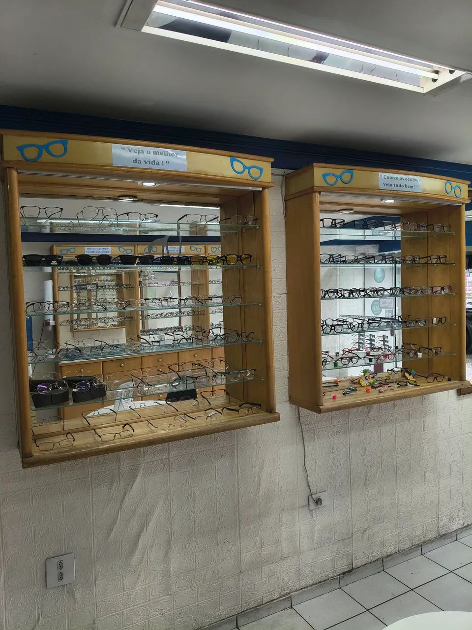 2 vitrines com 5 prateleiras de vidro e espelhos no fundo. 