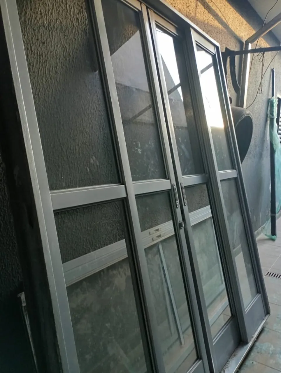 Porta de correr de vidro abre no meio