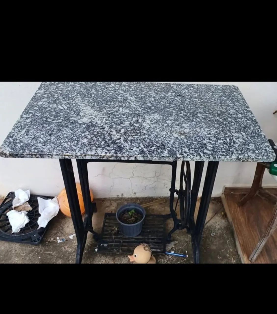 Mesa feita com base de máquina de costura antiga (ferro fundido) com tampo de granito.