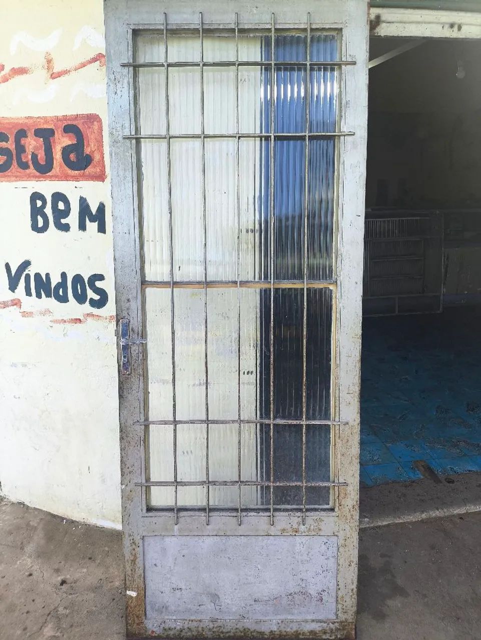 Porta de ferro com grade de proteção.