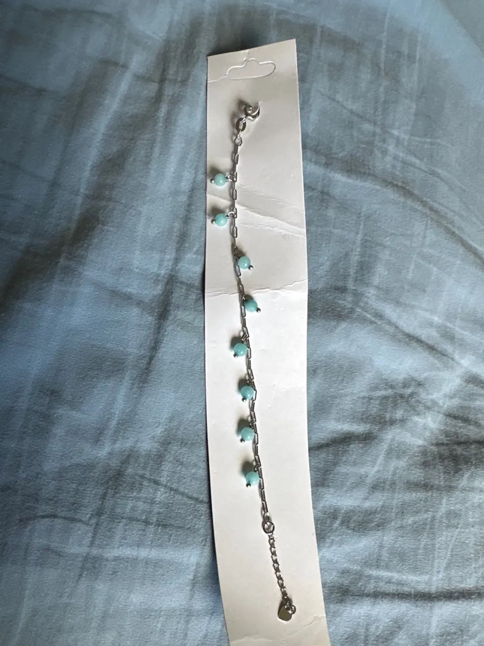 Pulseira prateada com pedrinhas azul clara 