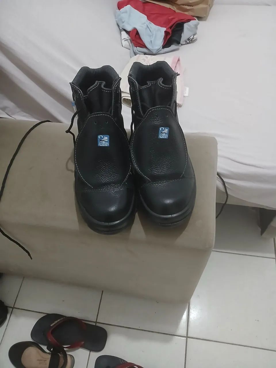 bota da marca marvalis e um par de havaianas ambas pretas 