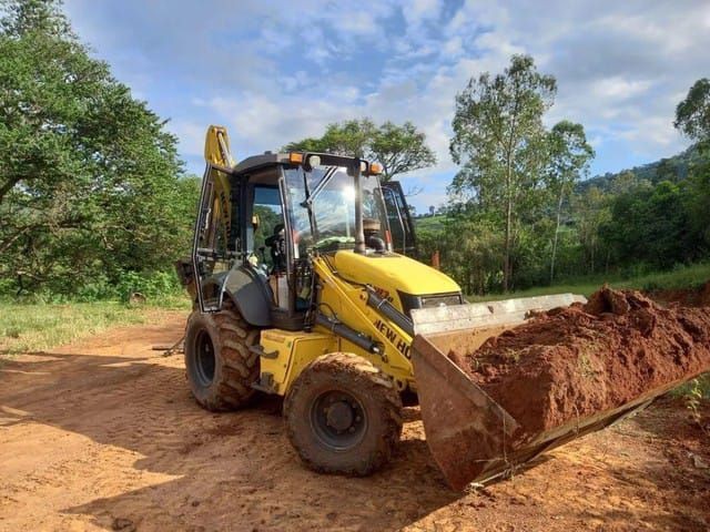 Retroescavadeira New Holland B110B funcionando perfeitamente.