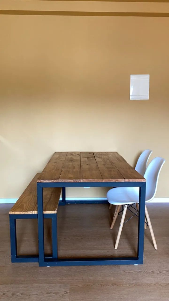 Mesa industrial com duas cadeiras e um banco