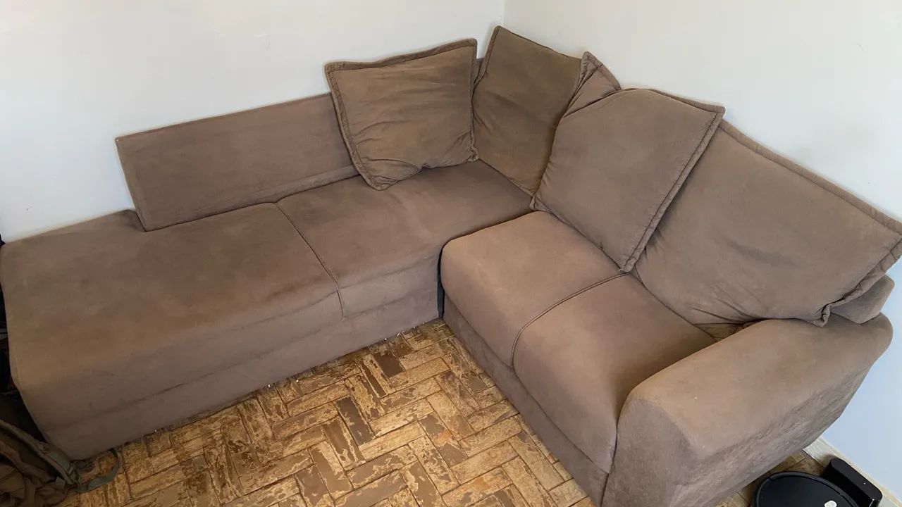 Sofá de canto marrom com 4 almofadas