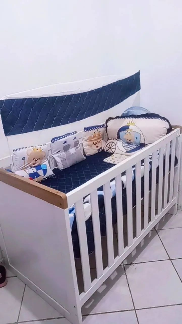 Berço de bebê branco com detalhes em madeira