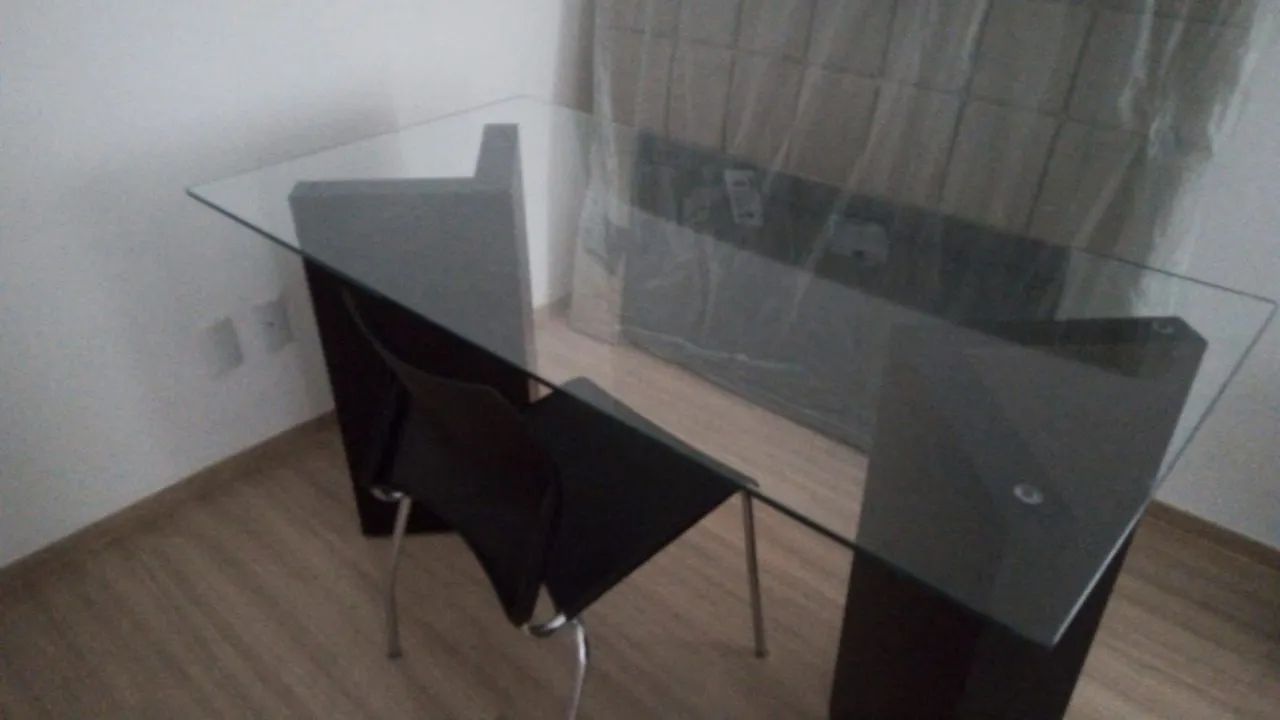 Mesa de vidro com duas cadeiras.