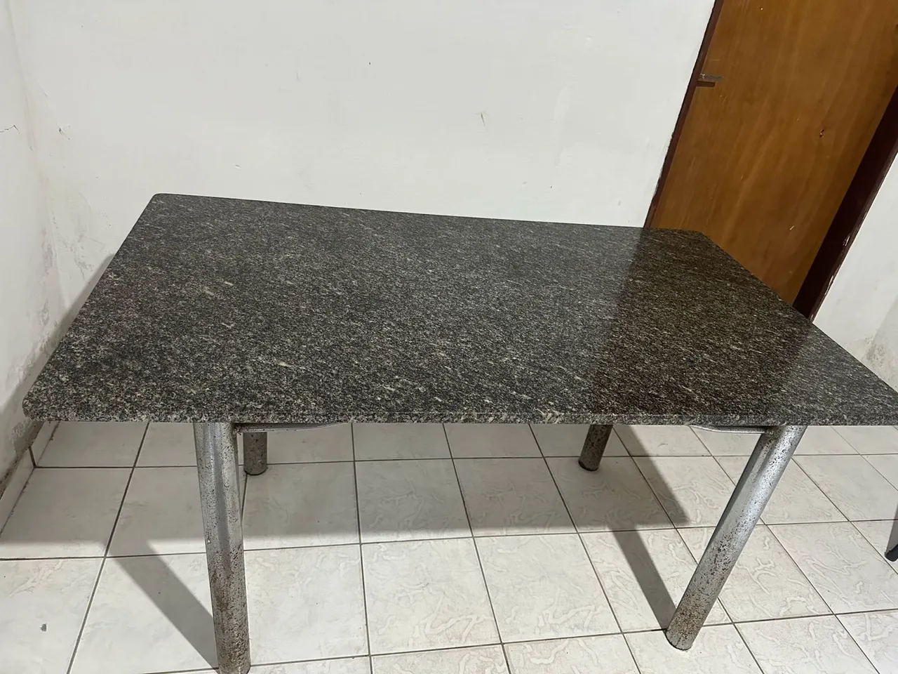 Mesa com tampo de granito e pés de metal