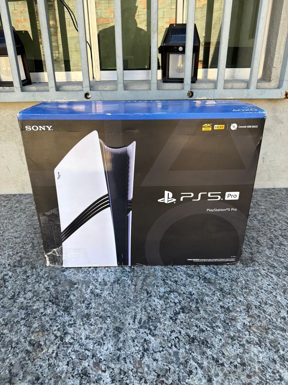 Caixa de PlayStation 5 pro, com luva, berço e manuais.