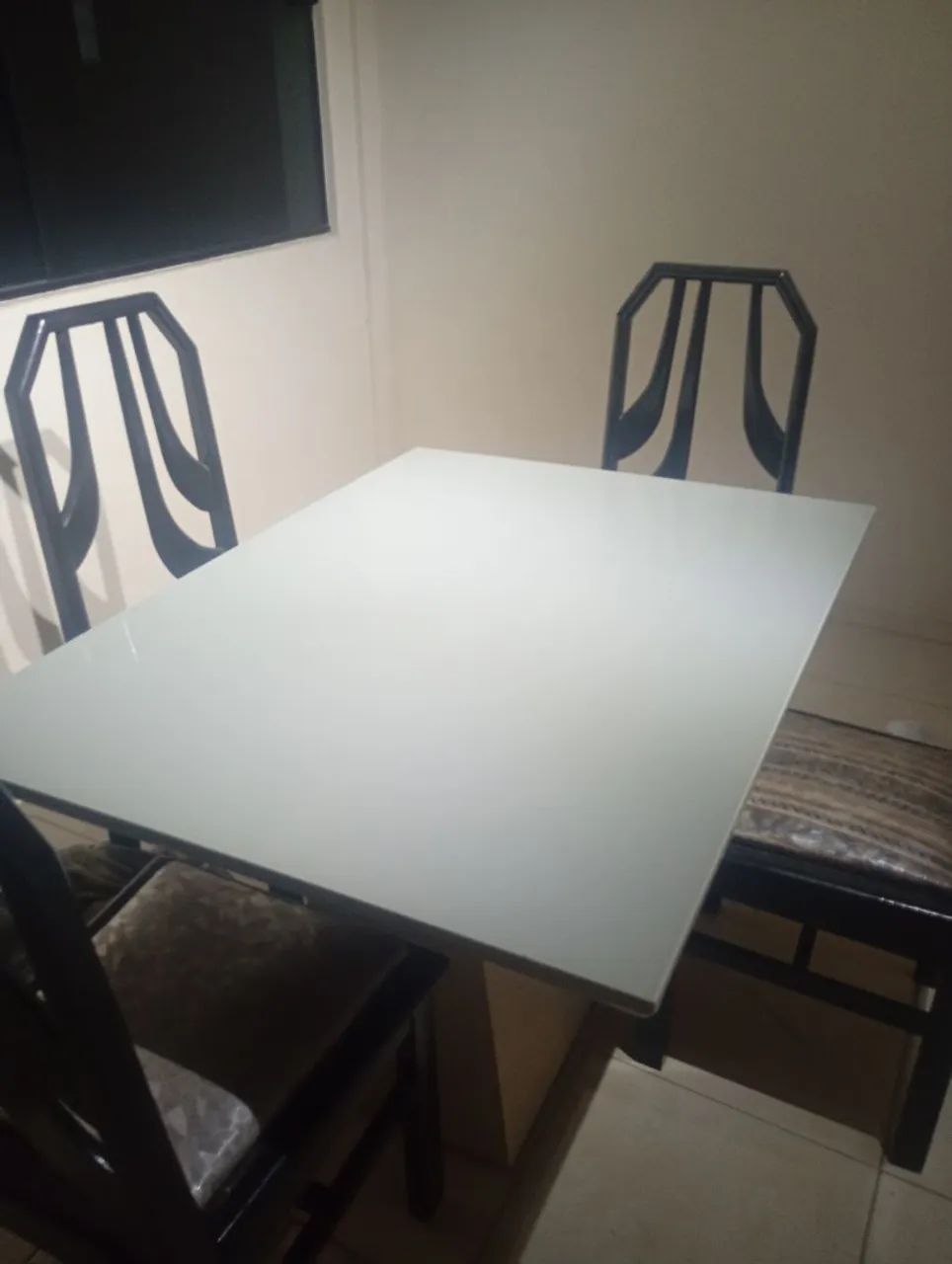 MESA DE JANTAR À VENDA<br>Mesa retangular com tampo de vidro branco e base central.