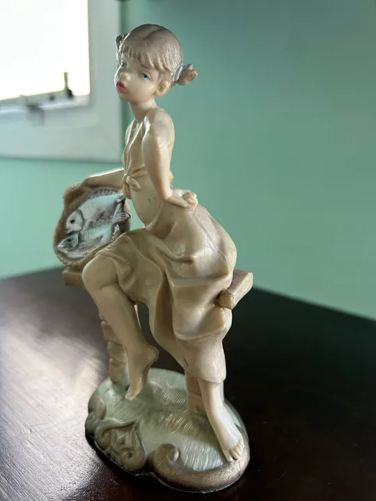 Escultura em resina da menina com cesto de peixes