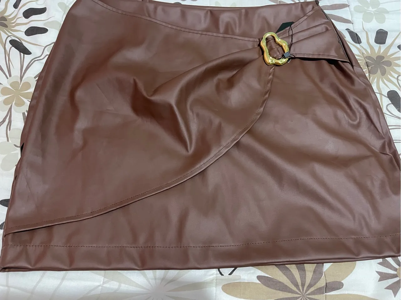 Saia marrom de couro sintético com detalhe dourado