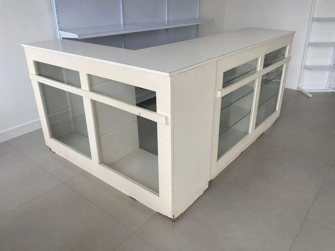 Balcão branco com prateleiras de vidro