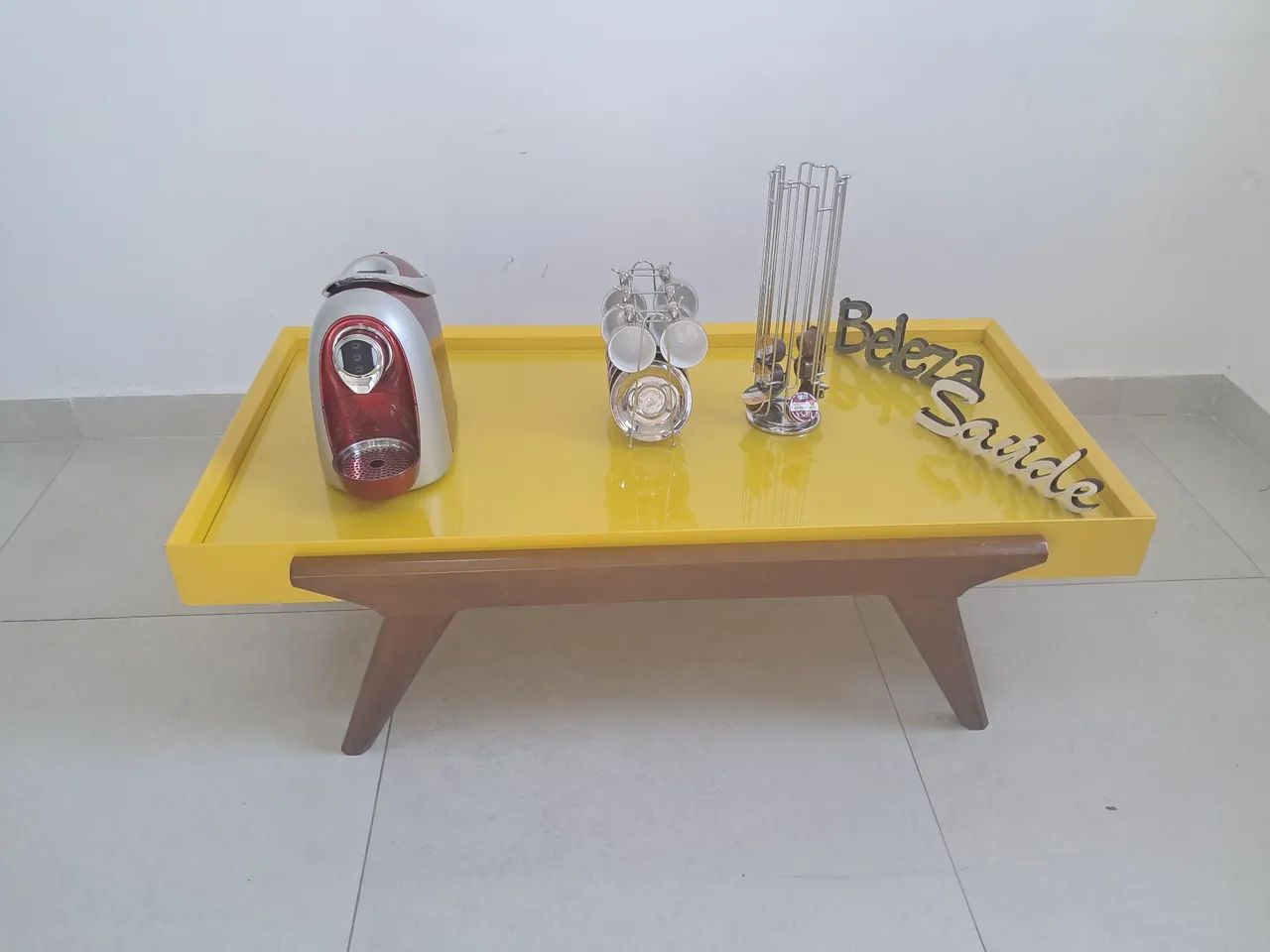 Mesa de centro em laca amarela e com os pés em madeira jequitibá