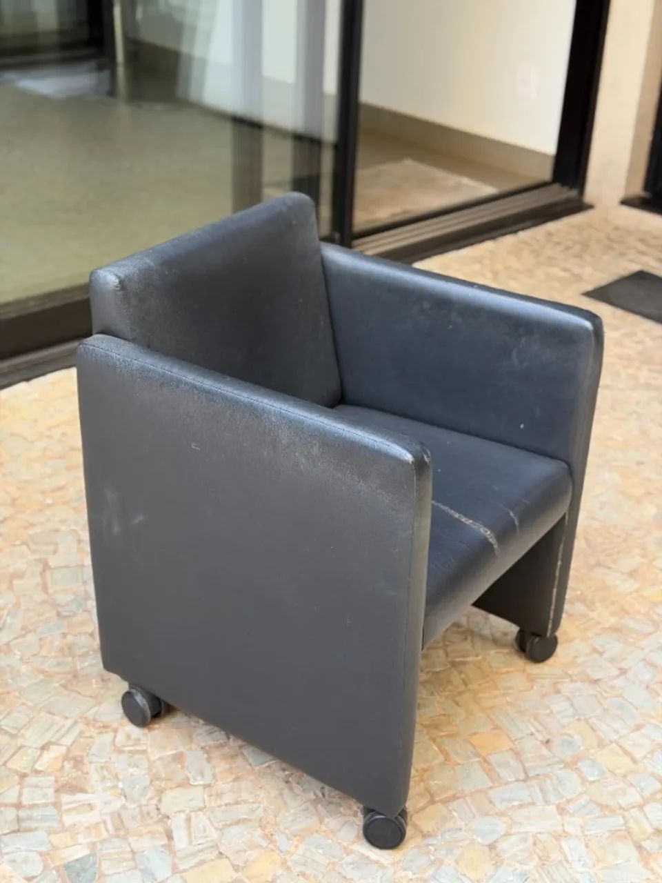 Poltrona com estofado preto e rodinhas 