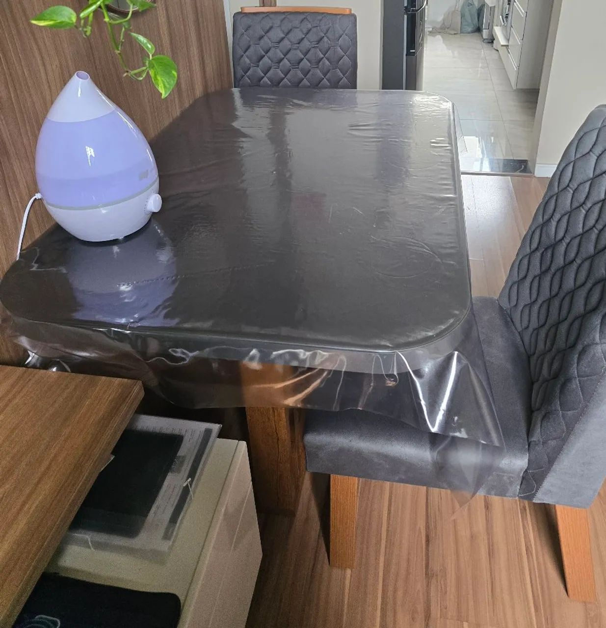 Mesa retangular cinza com 4 cadeiras.