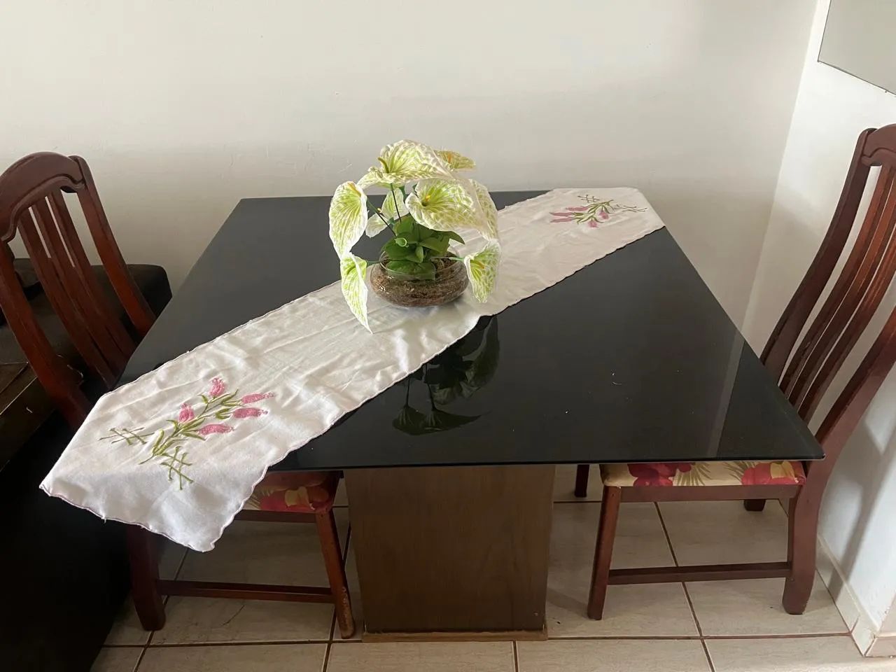 Mesa de vidro com duas cadeiras de madeira