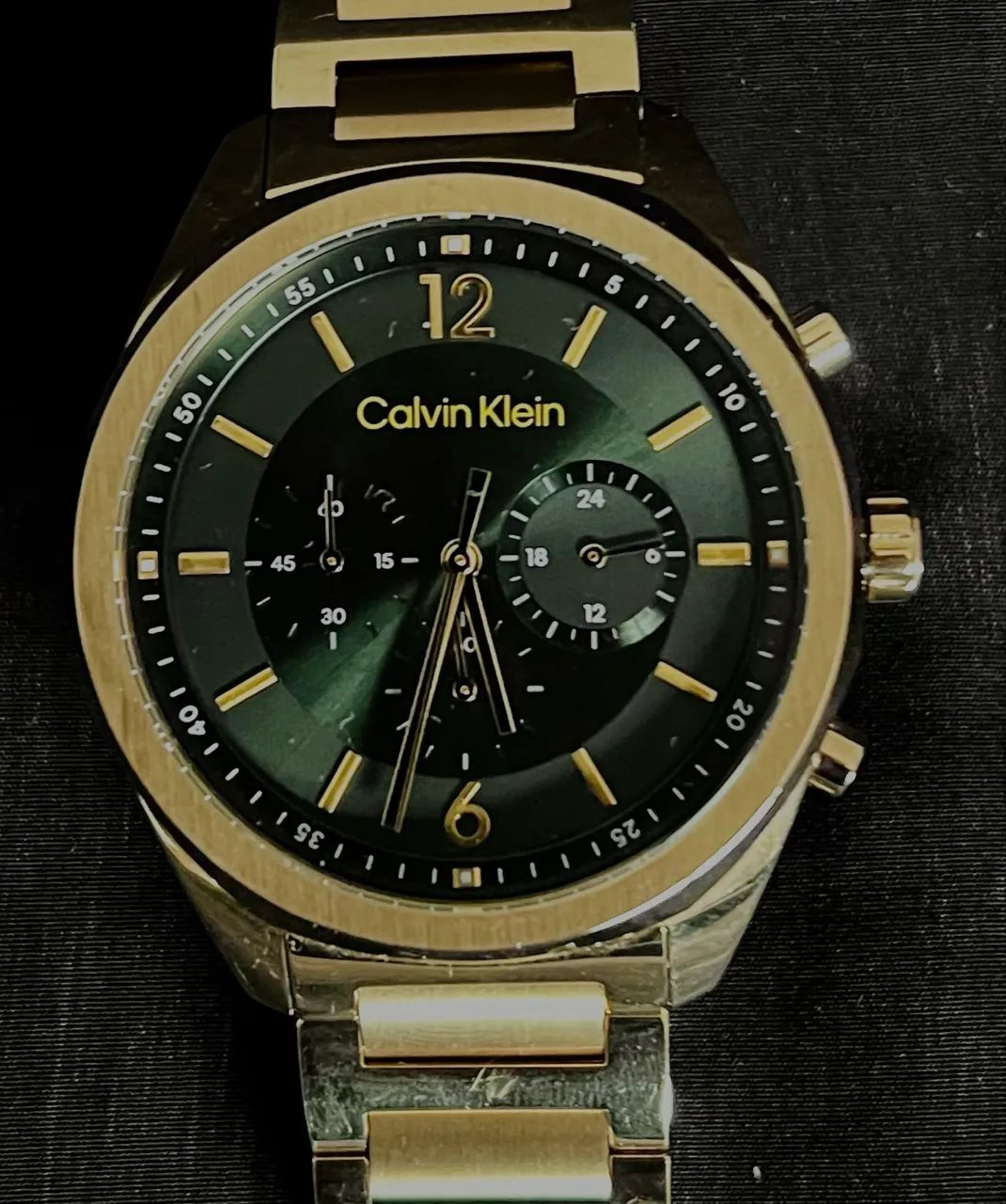 Relógio Calvin Klein com acabamento dourado e mostrador verde escuro.