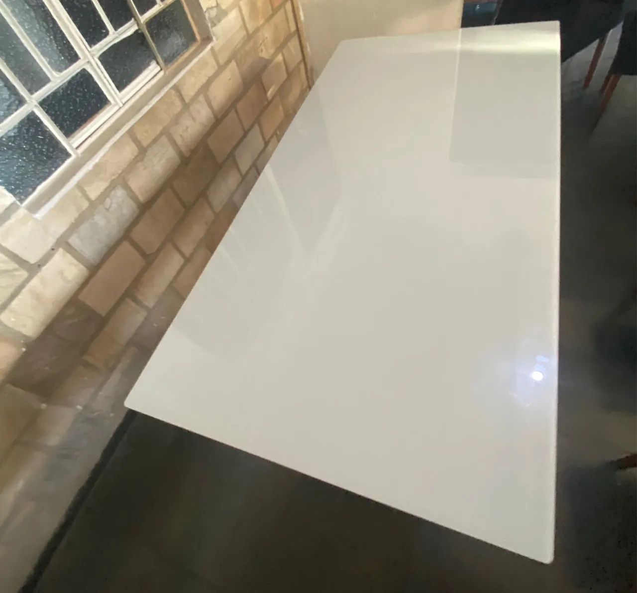 Mesa semi nova de vidro com oito cadeiras.