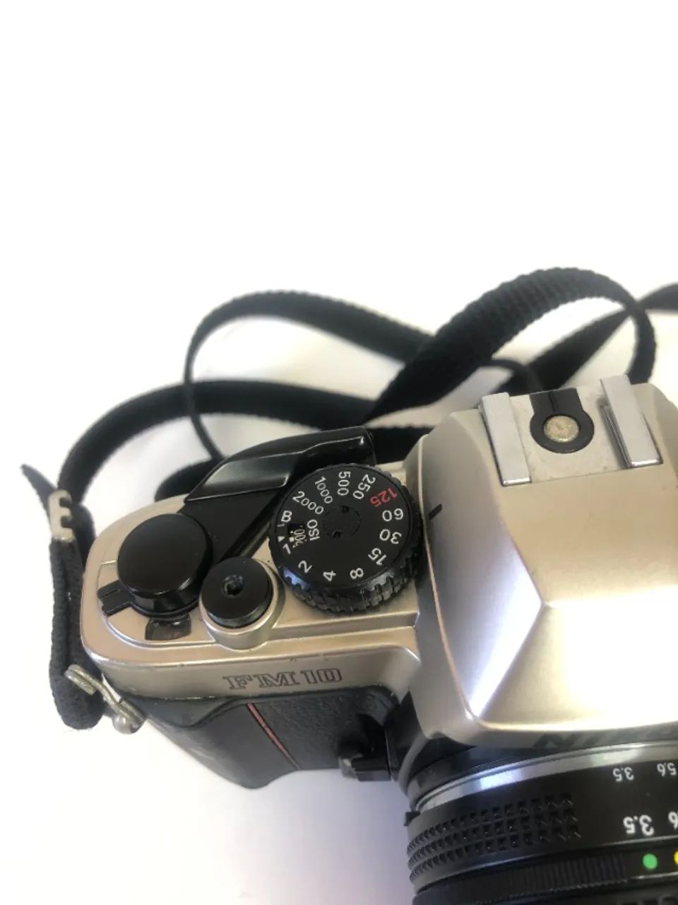 Câmera analógica Nikon FM10, com lente 35-70, possui alguns sinais