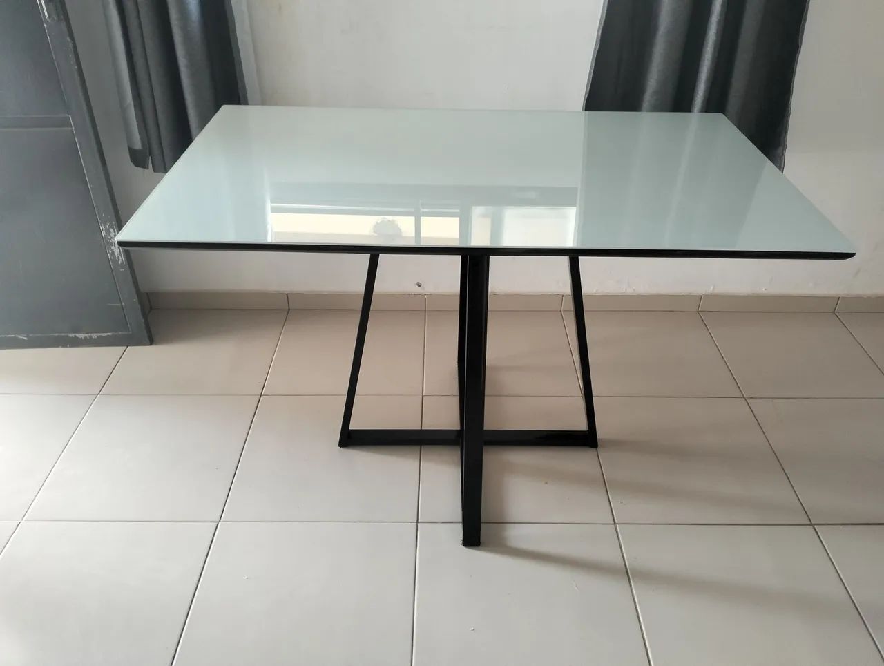 Mesa de jantar em vidro com base em ferro