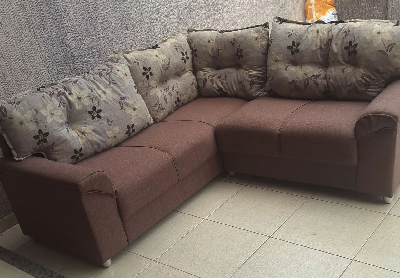 Sofa de canto marrom com almofadas 