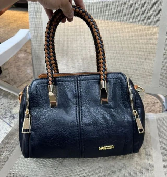Bolsa Baú média preta com alça transversal em couro sintético. 