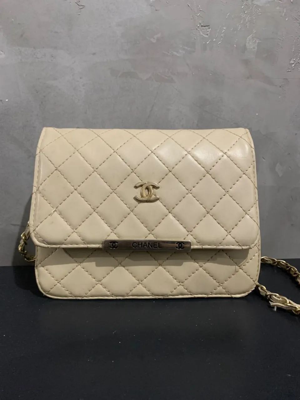 Bolsa estilo Chanel bege com matelassê e corrente dourada<br>