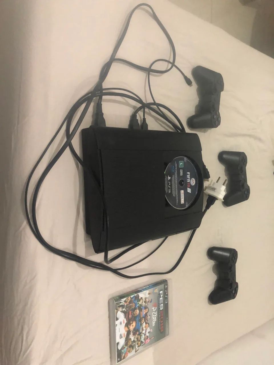 PlayStation3 com controles e jogos