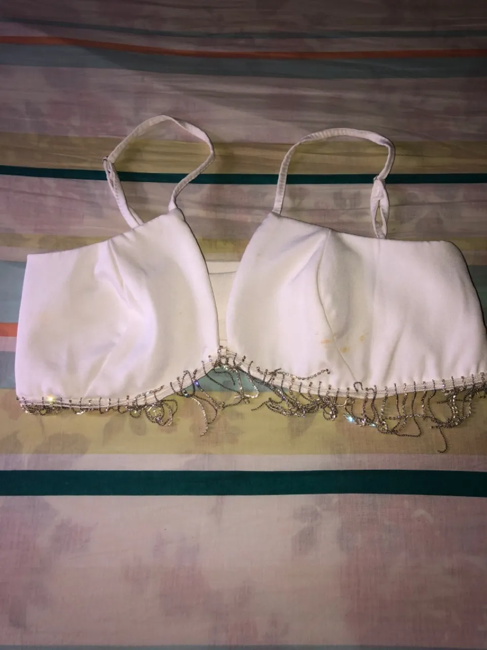 Top branco com detalhes é body com brilho