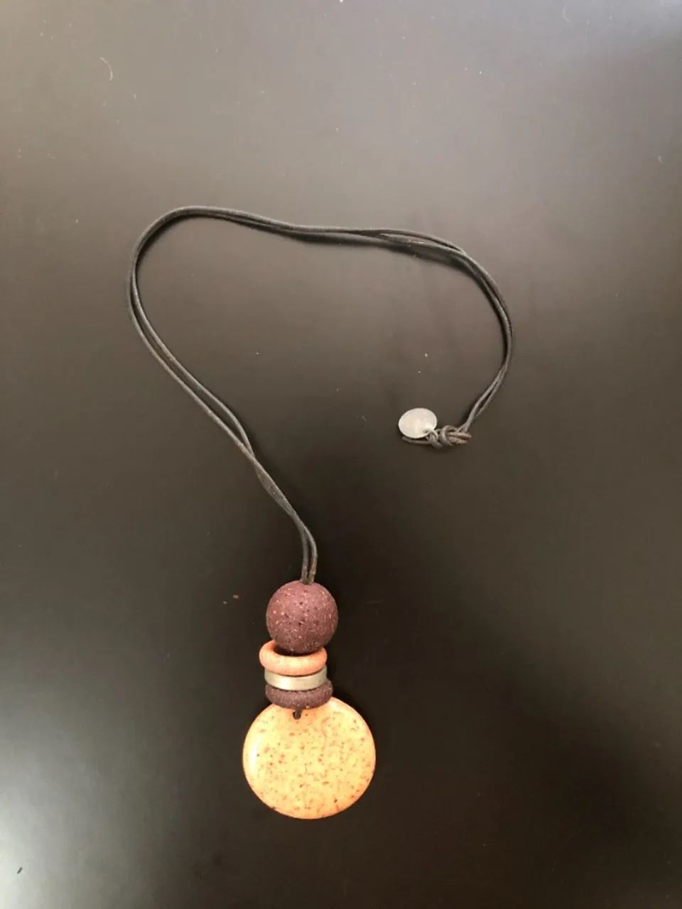 Colar minimalista com pingente em tons terra. Simples, mas não básico.