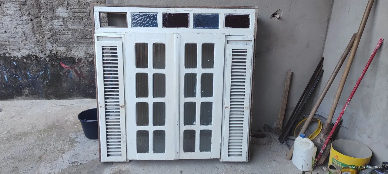 Janelas de madeira, sendo uma com detalhes em vidro e grade