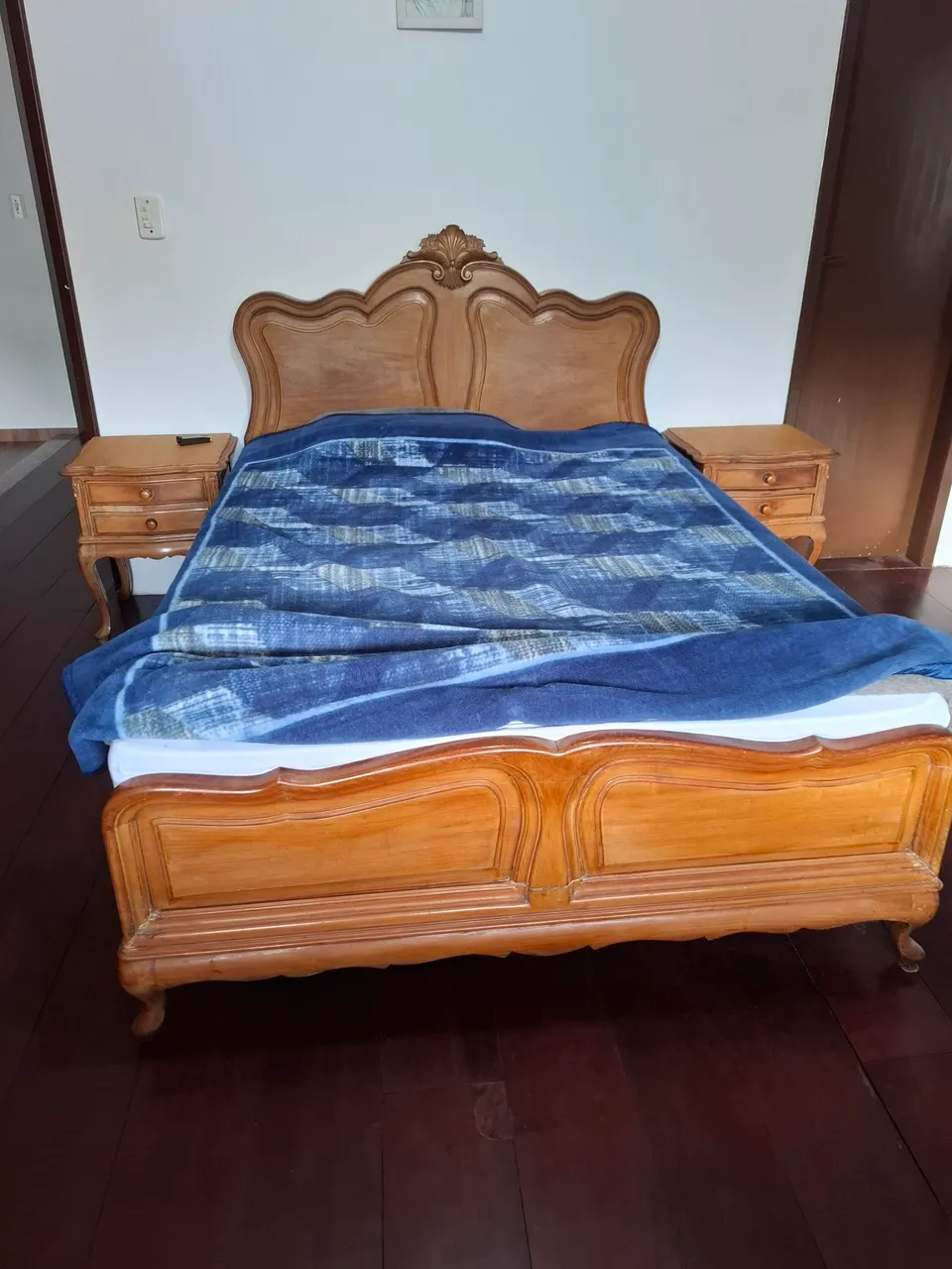 Cama de madeira entalhada com cabeceira e detalhes clássicos
