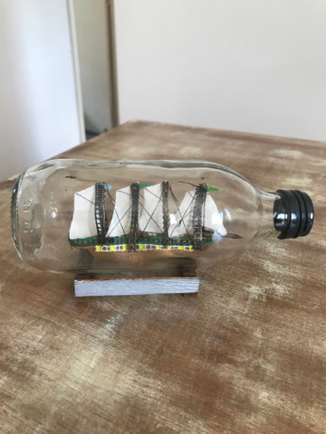 Miniatura de caravela dentro de garrafa