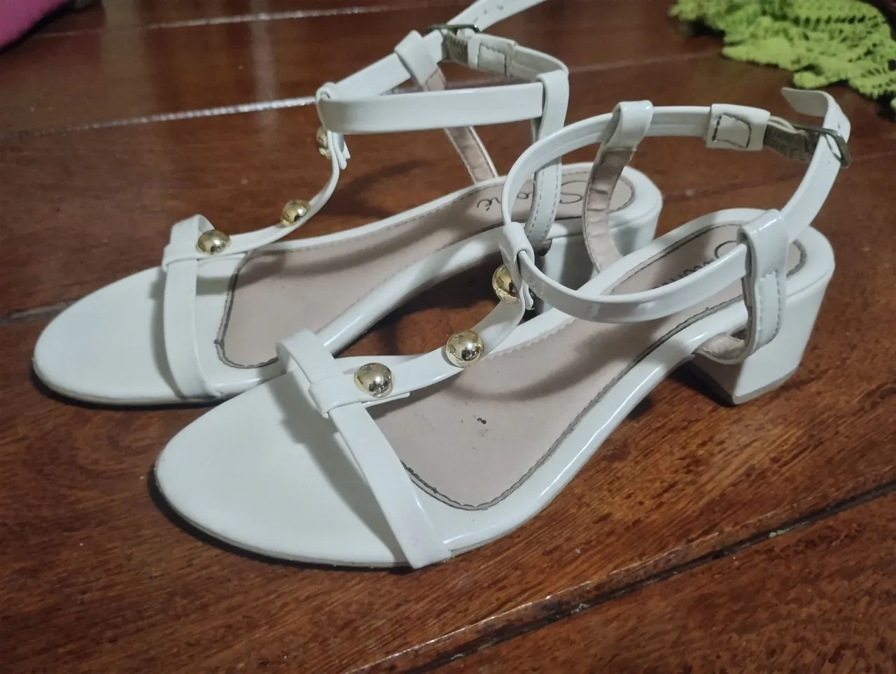 Sandálias infantis brancas com detalhes dourados