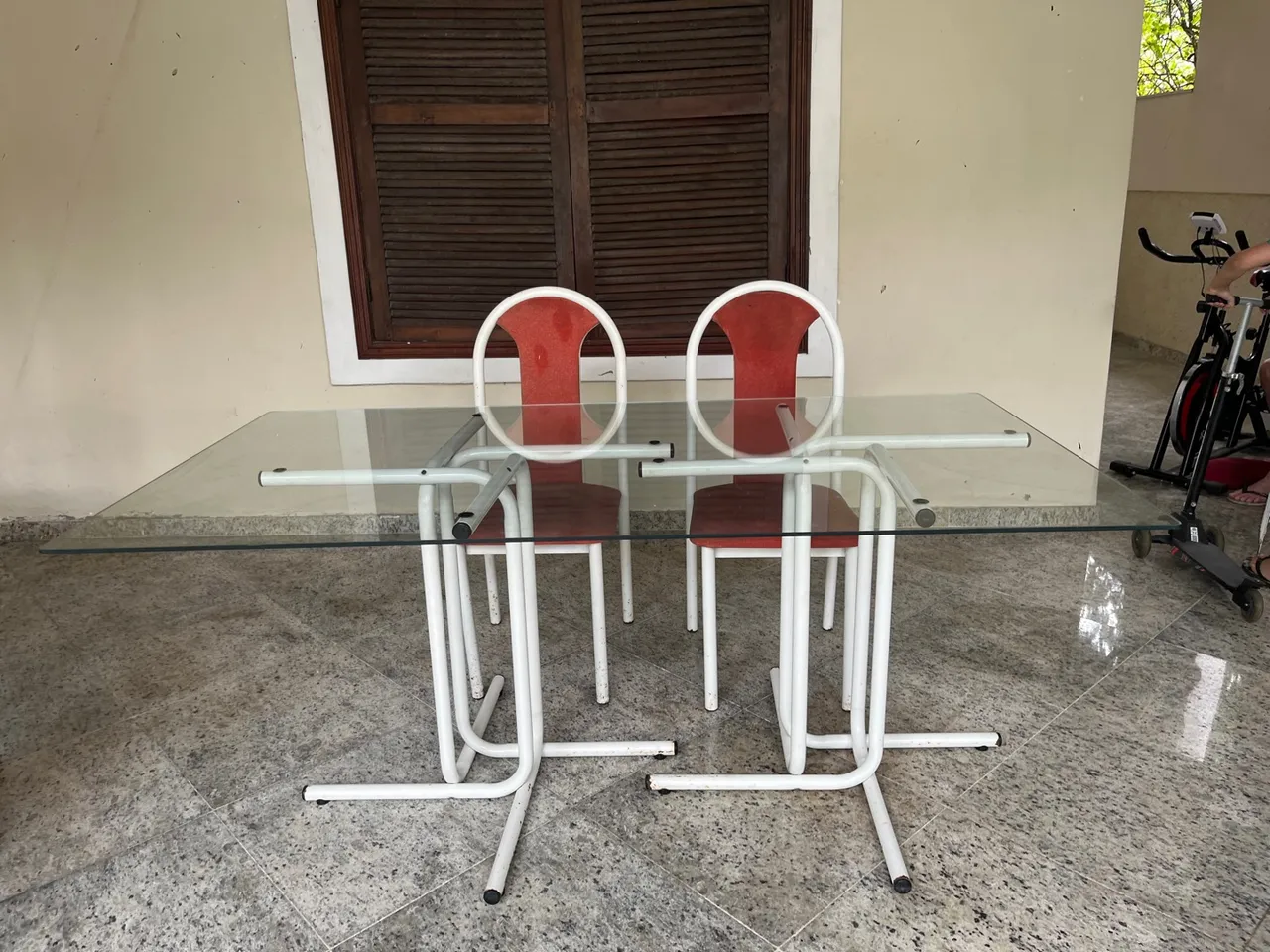 Mesa com tampo de vidro e seis cadeiras, usadas.