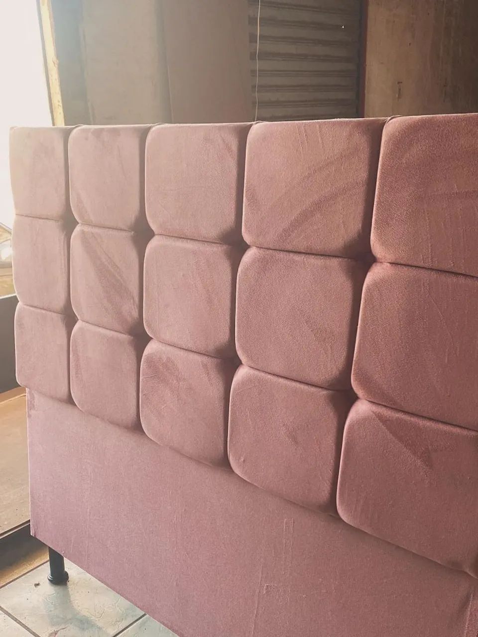 Linda cabeceira de cama estofada na cor rosa, com design moderno e elegante.