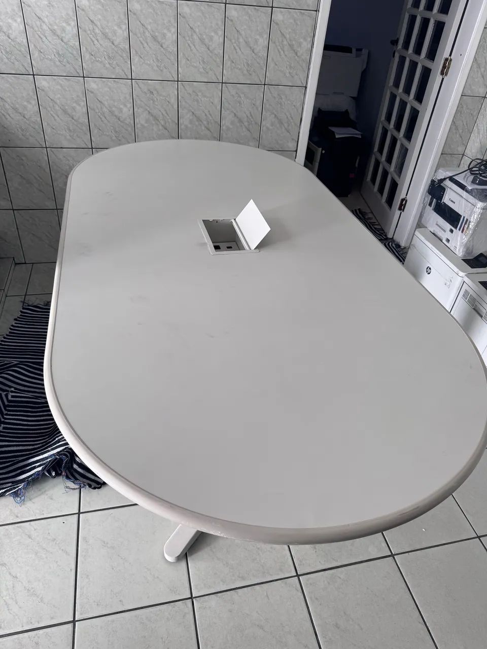 Mesa bancada oval para escritório com ponto de energia no centro