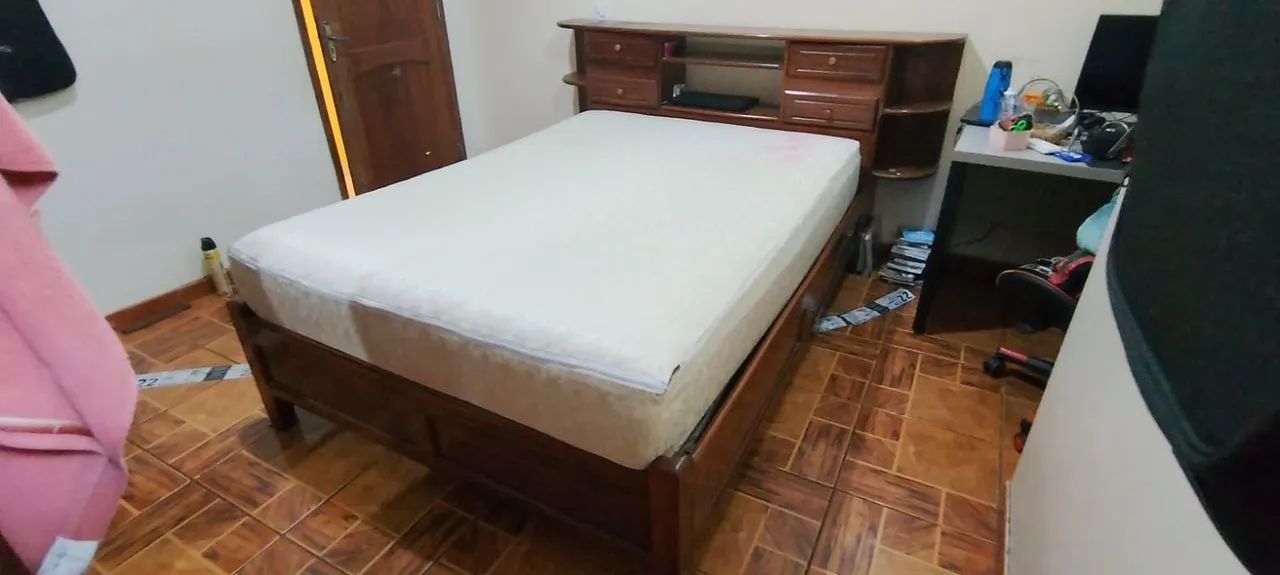 Cama de madeira com gaveteiros e baú na cabeceira