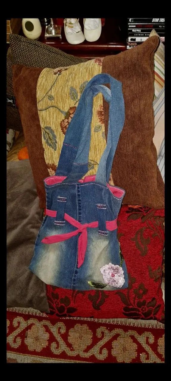 bolsa jeans artesanal decorada com uma flor rosa e laço.