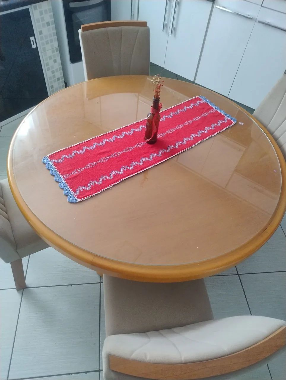 Mesa redonda de madeira com tempo de vidro com 4 cadeiras.